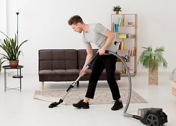 a man cleaning a carpet - Cahill's Carpet Cleaning